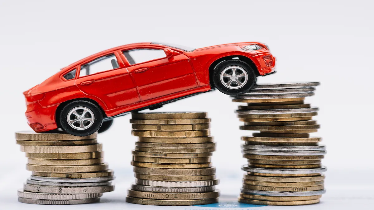 voiture rouge jouet sur la pile de pieces de monnaie croissantes sur fond blanc